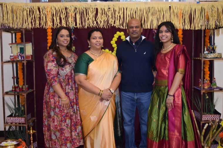 A family in front of the Pongal decorations at Pongal 2024